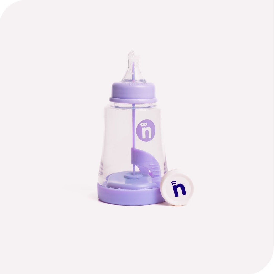 The Smart Bottle is shown with the Smart Sensor, which wirelessly transmits a baby's feeding data to our Tracker App.
