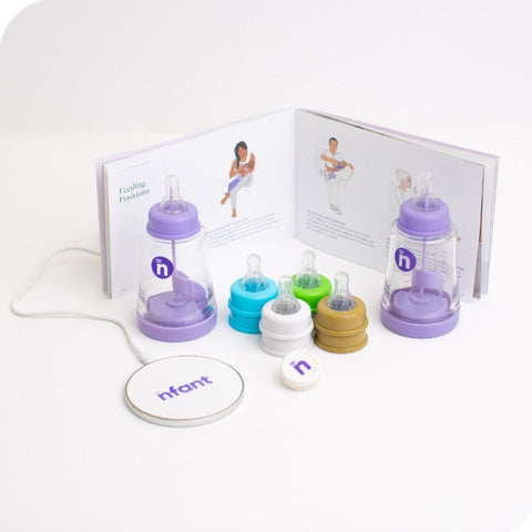 The nfant® Thrive Feeding System is shown with all of its contents, which include: 2 Smart Bottles, 1 Smart Sensor, a wireless charger, 10 bottle nipples at assorted flow rates and our Connected Feeding program guide.